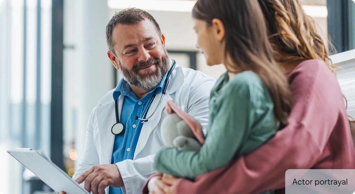 Actor portrayal of doctor with woman and child