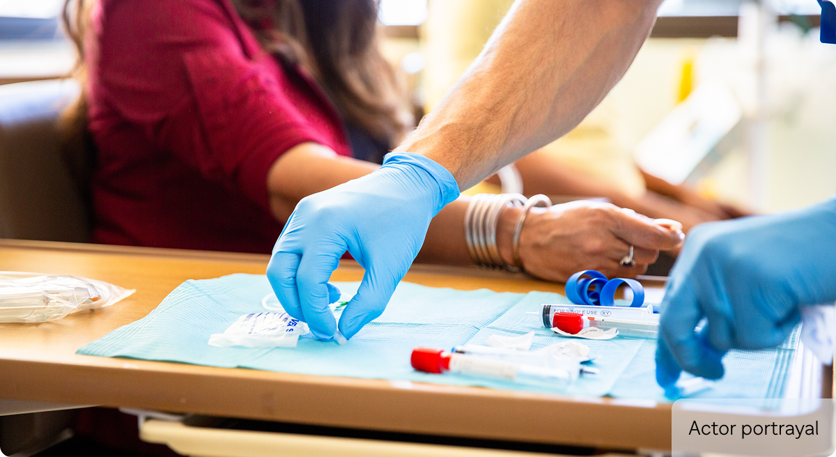 Actor portrayal of phlebotomist preparing blood draw